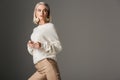 elegant blonde model posing in white knitted sweater Royalty Free Stock Photo