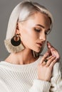 elegant blonde model posing in white sweater and big round earrings Royalty Free Stock Photo