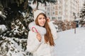 Elegant blonde woman posing with happy smile eating sweet candy cane in winter day. Portrait of gorgeous european girl Royalty Free Stock Photo