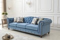 Elegant Blue Tufted Chesterfield Sofa with Decorative Pillows in a Luxurious Interior couch Royalty Free Stock Photo