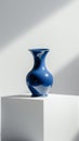 Elegant blue vase on a white pedestal under dramatic lighting Royalty Free Stock Photo