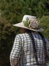 Elegant Bolivian woman with two braids wearing a fancy flower hat and a woven sweter with square pattern