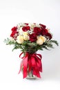 Elegant bouquet of red, white roses, decorated with fern leaves, ribbons, flowers clear vase white Royalty Free Stock Photo