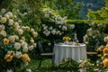 Elegant breakfast table surrounded by beautiful white and yellow roses in a garden setting