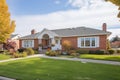 elegant brick cape cod home with bay window and front lawn Royalty Free Stock Photo