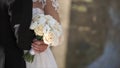 Elegant bride and groom posing together outdoors on a wedding day. Bride holding a white rose bouquet while standing Royalty Free Stock Photo