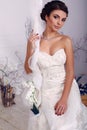 Elegant bride in wedding dress sitting on swing at studio