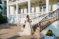 Elegant bride with wedding flowers bouquet, attractive woman in wedding dress. Young girl in a white dress goes the Royalty Free Stock Photo