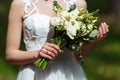 Elegant bride in a white wedding dress with lace holding in hand