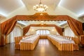 Elegant banquet hall interior in white and terracotta tones with tables prepared for festive celebration Royalty Free Stock Photo