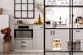 Elegant bright kitchen interior with white cupboards and black shelf