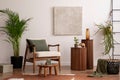 Elegant and bright space of living room with mock up poster, wooden coffee table and beige armchair with green pillow. Beige wall