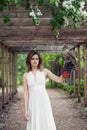 Elegant brunette bride woman in white dress holding hawk bird, outdoors portrait Royalty Free Stock Photo