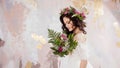 Elegant brunette girl bride with flowers. Beautiful young bride in a lush wedding wreath of fresh flowers Royalty Free Stock Photo