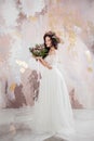 Elegant brunette girl bride with flowers. Beautiful young bride in a lush wedding wreath of fresh flowers Royalty Free Stock Photo