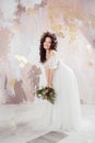 Elegant brunette girl bride with flowers. Beautiful young bride in a lush wedding wreath of fresh flowers. Royalty Free Stock Photo