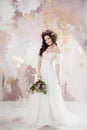 Elegant brunette girl bride with flowers. Beautiful young bride in a lush wedding wreath of fresh flowers Royalty Free Stock Photo