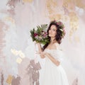 Elegant brunette girl bride with flowers. Beautiful young bride in a lush wedding wreath of fresh flowers. Royalty Free Stock Photo