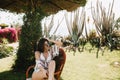 Elegant brunette girl sitting in the wooden chair outside, enjoying exotic landscape. Amazing slim young woman in white Royalty Free Stock Photo