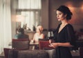 Elegant brunette lady in black evening dress with glass of red w