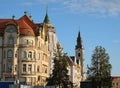 Elegant buildings and bell tower of St. Ladislaus Roman-Catholic Church in Union Square of Oradea.