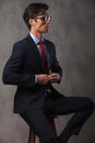 Elegant business man buttoning his suit while sitting Royalty Free Stock Photo