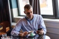 Connected and Chic: A Stylish Businessman Engaging with Technology and Coffee