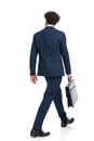 Elegant businessman in suit holding suitcase and walking Royalty Free Stock Photo