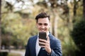 Elegant businessman using smartphone in the park Royalty Free Stock Photo