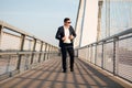 Elegant businessman walking on the bridge during sunset Royalty Free Stock Photo