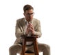 Elegant businessman wearing glasses holding hands on wooden chair Royalty Free Stock Photo