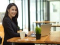 Elegant businesswoman in black suit typing on laptop keyboard at cafe Royalty Free Stock Photo