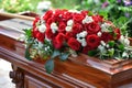 Elegant casket adorned with red and white roses in an outdoor setting. Royalty Free Stock Photo