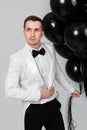 caucasian man in white suit tuxedo with black air balloons Royalty Free Stock Photo