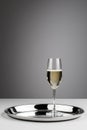 Elegant champagne glass on silver serving tray in minimalist setting Royalty Free Stock Photo