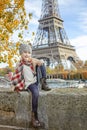 Elegant child on embankment in Paris sitting on the parapet