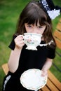 Elegant child girl having a tea party outdoors