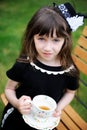 Elegant child girl having a tea party outdoors
