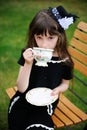 Elegant child girl having a tea party outdoors