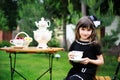 Elegant child girl having a tea party outdoors