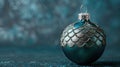 Elegant Christmas ornament showcasing a detailed silver snake scale texture, presented against a minimalist deep teal Royalty Free Stock Photo