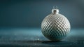 Elegant Christmas ornament showcasing a detailed silver snake scale texture, presented against a minimalist deep teal Royalty Free Stock Photo