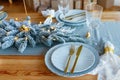 Elegant christmas table setting in gold and blue color for holiday dinner. Christmas or New Years celebration party Royalty Free Stock Photo