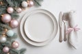 Elegant Christmas Table Setting with Soft Pastel Ornaments and White Dinnerware Royalty Free Stock Photo