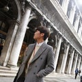 Elegant cinese man walking in street in Venice. Italy
