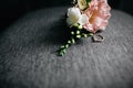 Elegant and classy groom boutonniere with amazing pink and white colored rose and wedding rings Royalty Free Stock Photo