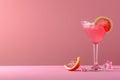 Elegant cocktail glass with citrus garnish on pink background Royalty Free Stock Photo