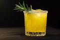 Elegant cocktail with rosemary garnish on a dark background