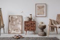 Elegant composition of masculine room decor with small wooden cupboard, two mockup paintings and vintage accessories.