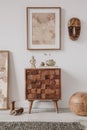 Elegant composition of masculine room decor with small wooden cupboard, two mockup paintings and vintage accessories.